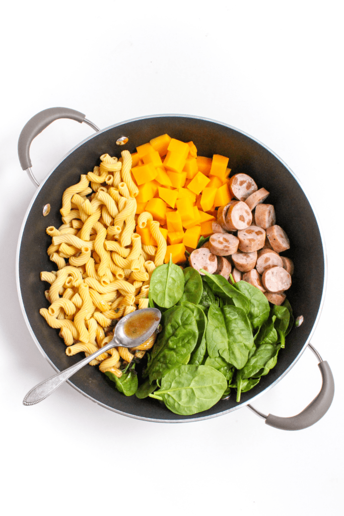 sage butter pasta with chicken sausage in a large skillet