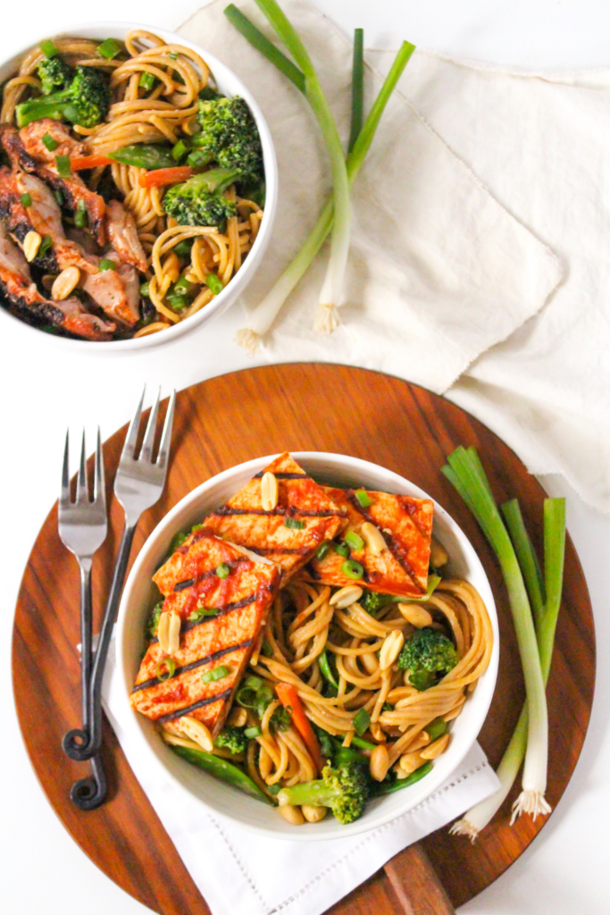 peanut butter noodles with veggies and bbq tofu in a bowl