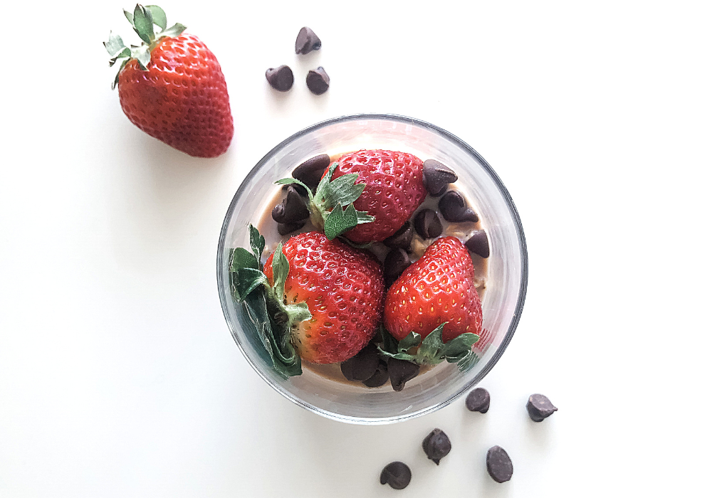 strawberry chocolate oatmeal in a jar with strawberries and chocolate chips