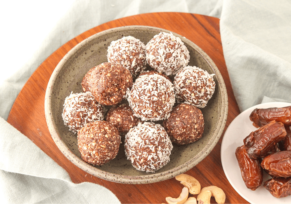 chocolate bliss balls with cashews and dates on a plate
