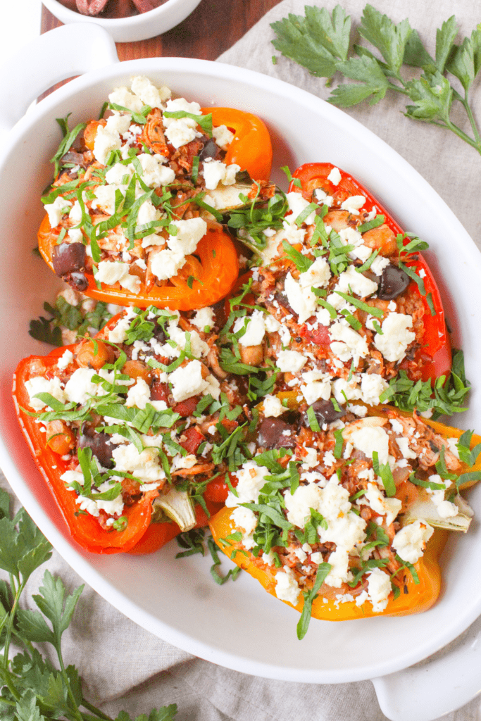 greek stuffed peppers with chicken and feta in a white baking dish