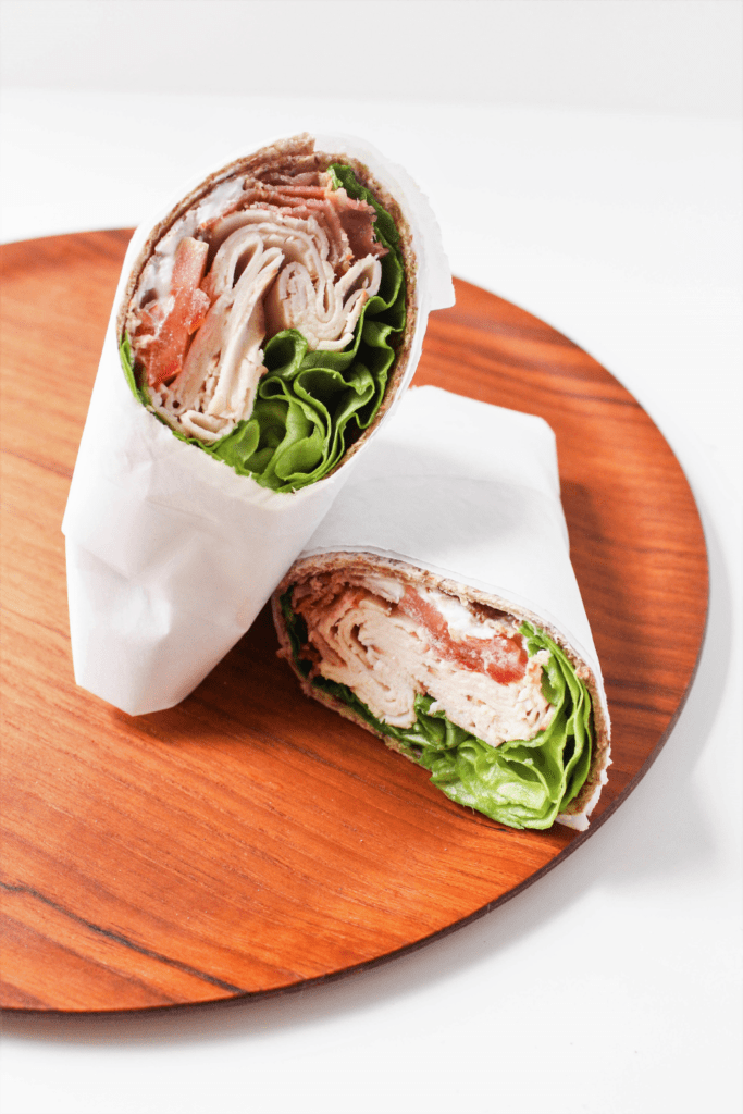 turkey club wrap with bacon on a wooden platter