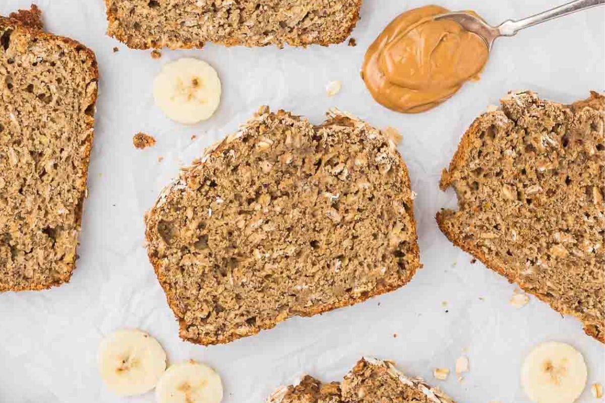 slices of oatmeal banana bread with a spoonful of peanut butter beside them