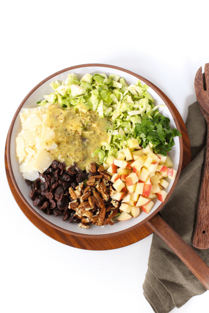 fall salad with homemade dressing, cranberries, and pecans in a bowl