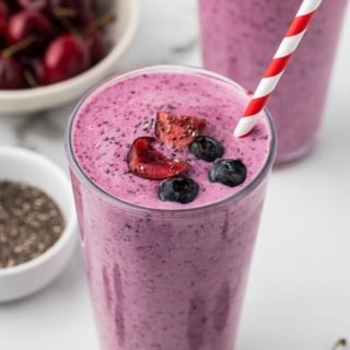 berry smoothie with chia seeds and Greek yogurt in a glass with a striped straw