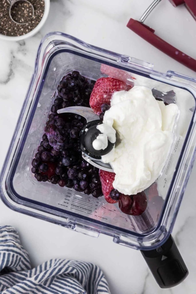 strawberries, cherries, blueberries, and Greek yogurt in a blender