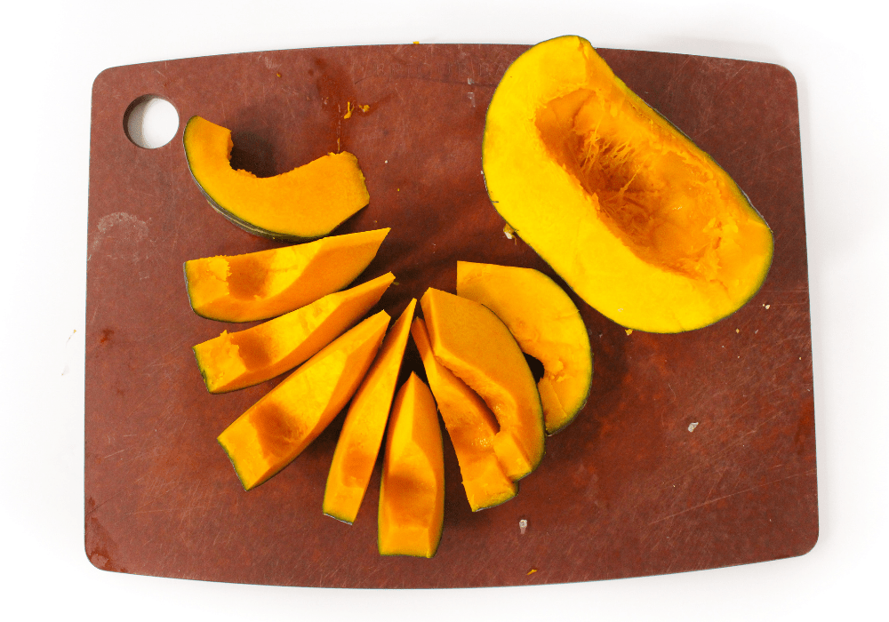 sliced buttercup squash on a wooden cutting board