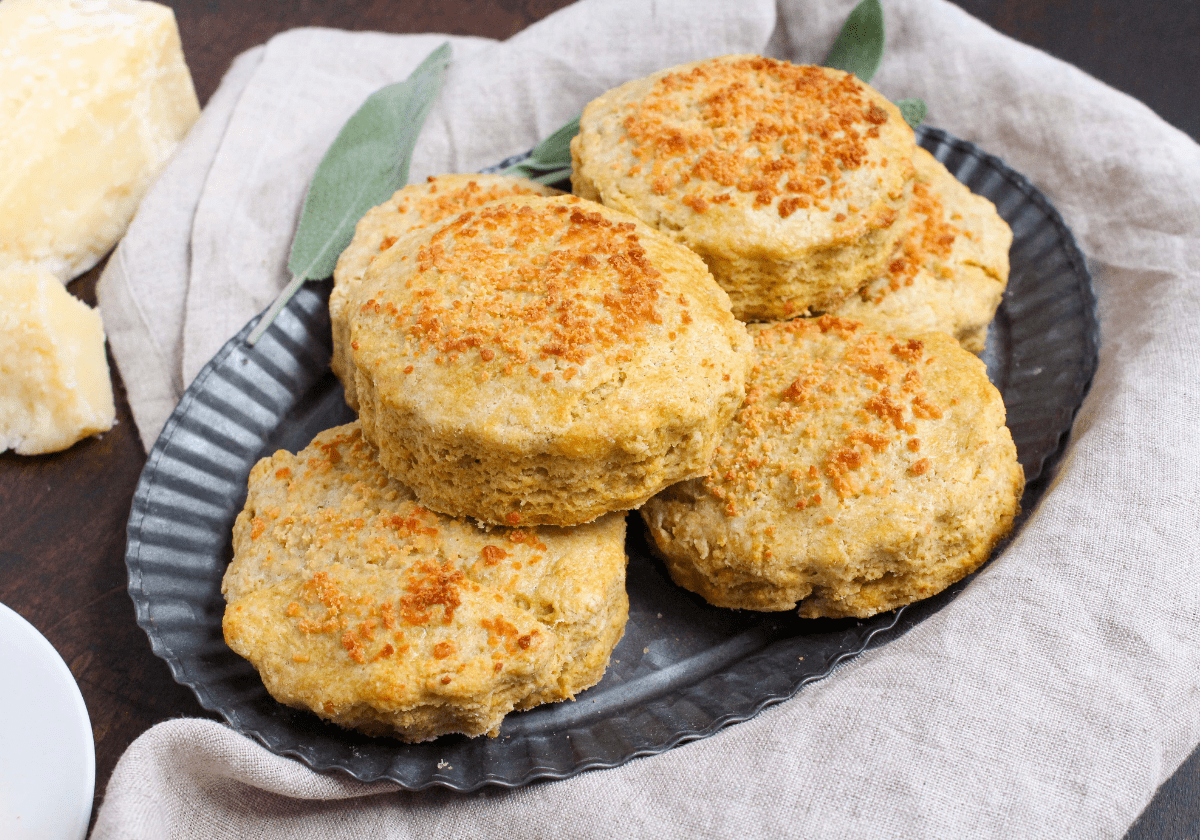 butternut squash parmesan biscuits on a metal serving plate with fresh sage