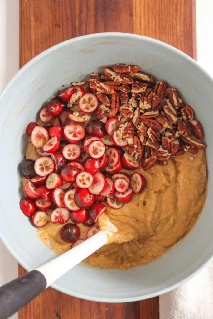 bread batter in a bowl with cranberries and pecans