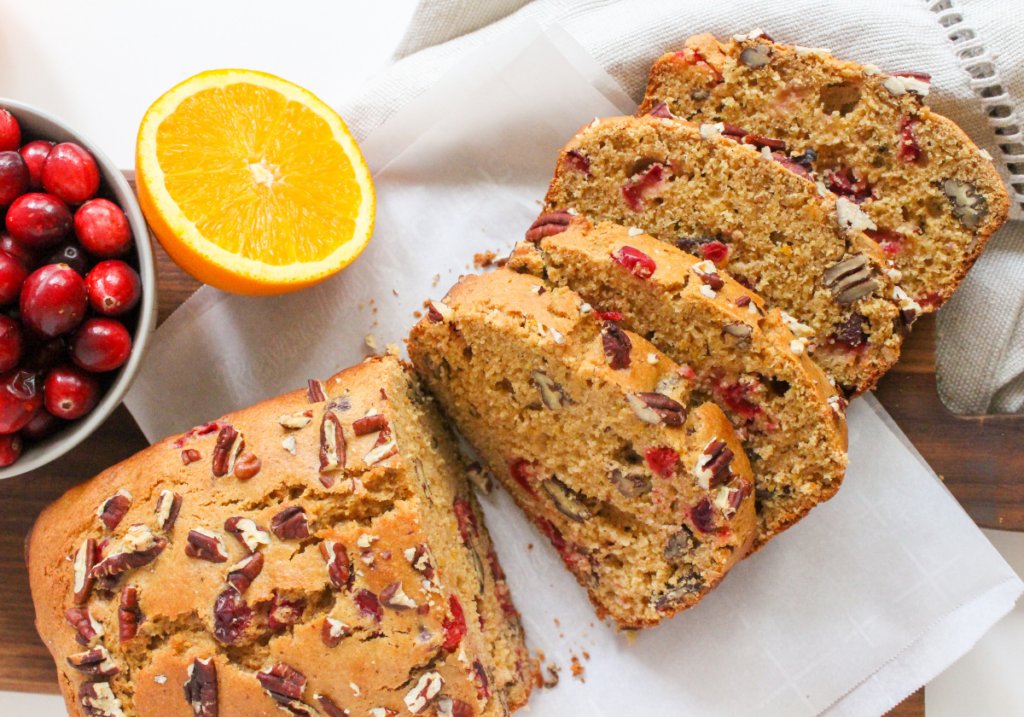 sliced cranberry orange bread with a bowl of cranberries