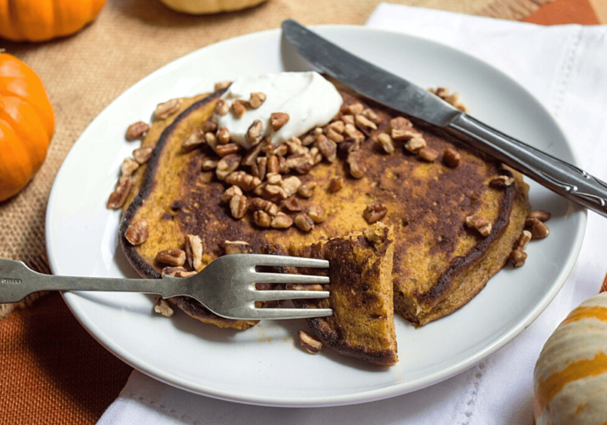 pumpkin pancakes topped with chopped nuts and greek yogurt