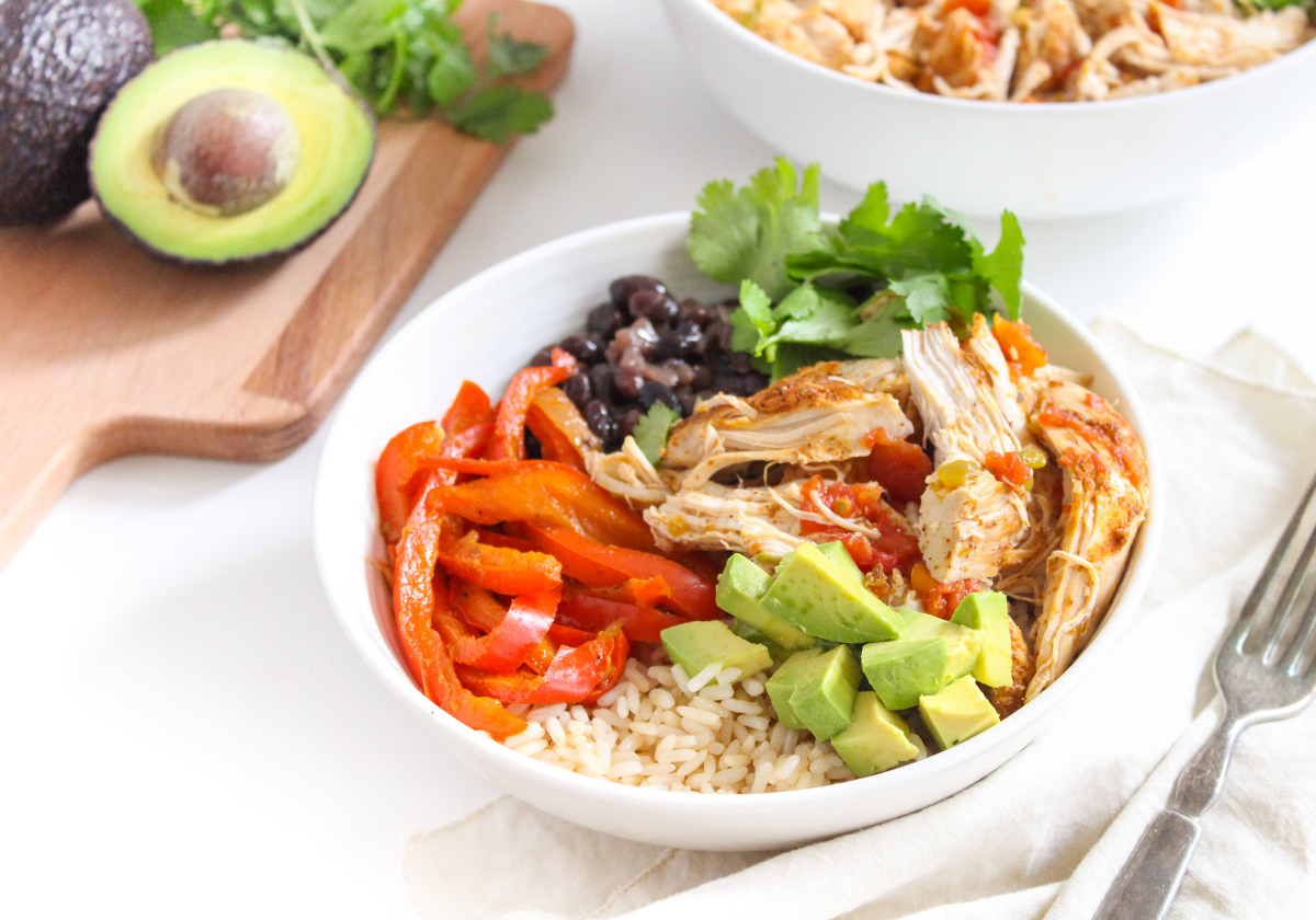 Instant Pot Mexican shredded chicken in a bowl with veggies, avocado, and rice