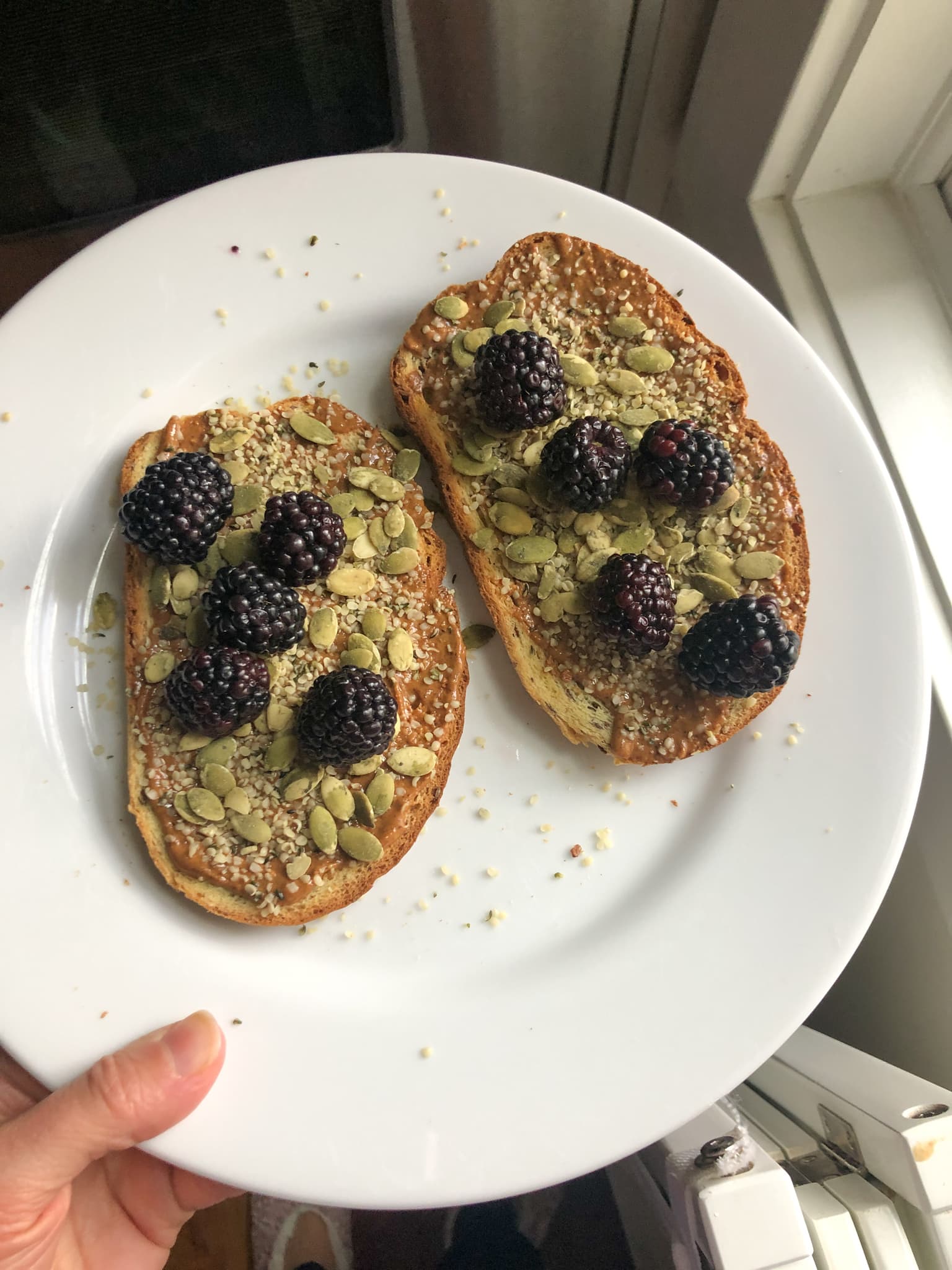 toast with nut butter, sprouted pumpkin seeds, and blackberries