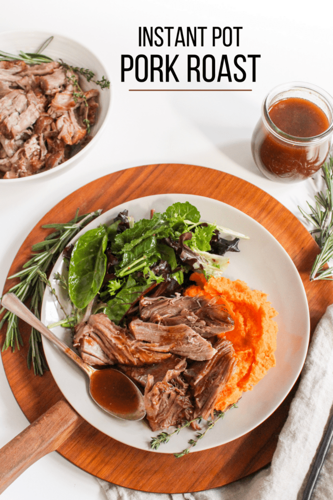 Instant Pot pork roast on a plate with gravy in a jar
