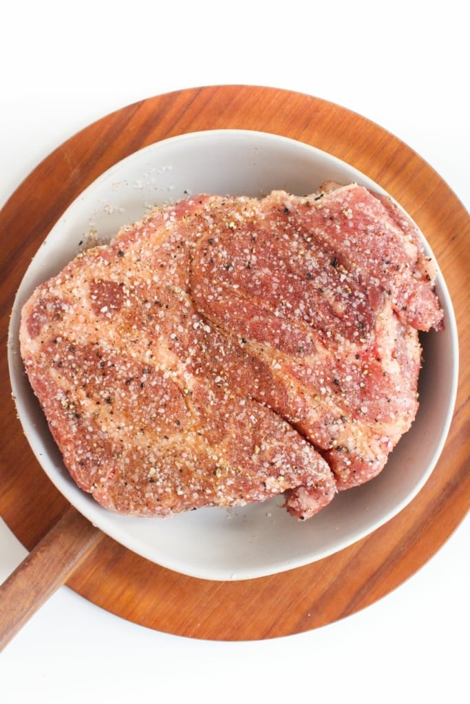 raw pork shoulder in a bowl with seasonings