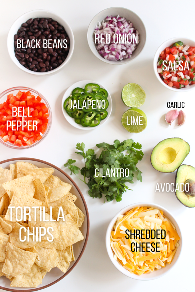 tortilla chips, diced bell pepper, black beans, diced red onion, salsa, garlic, lime, avocado, cilantro, and shredded cheese in small bowls