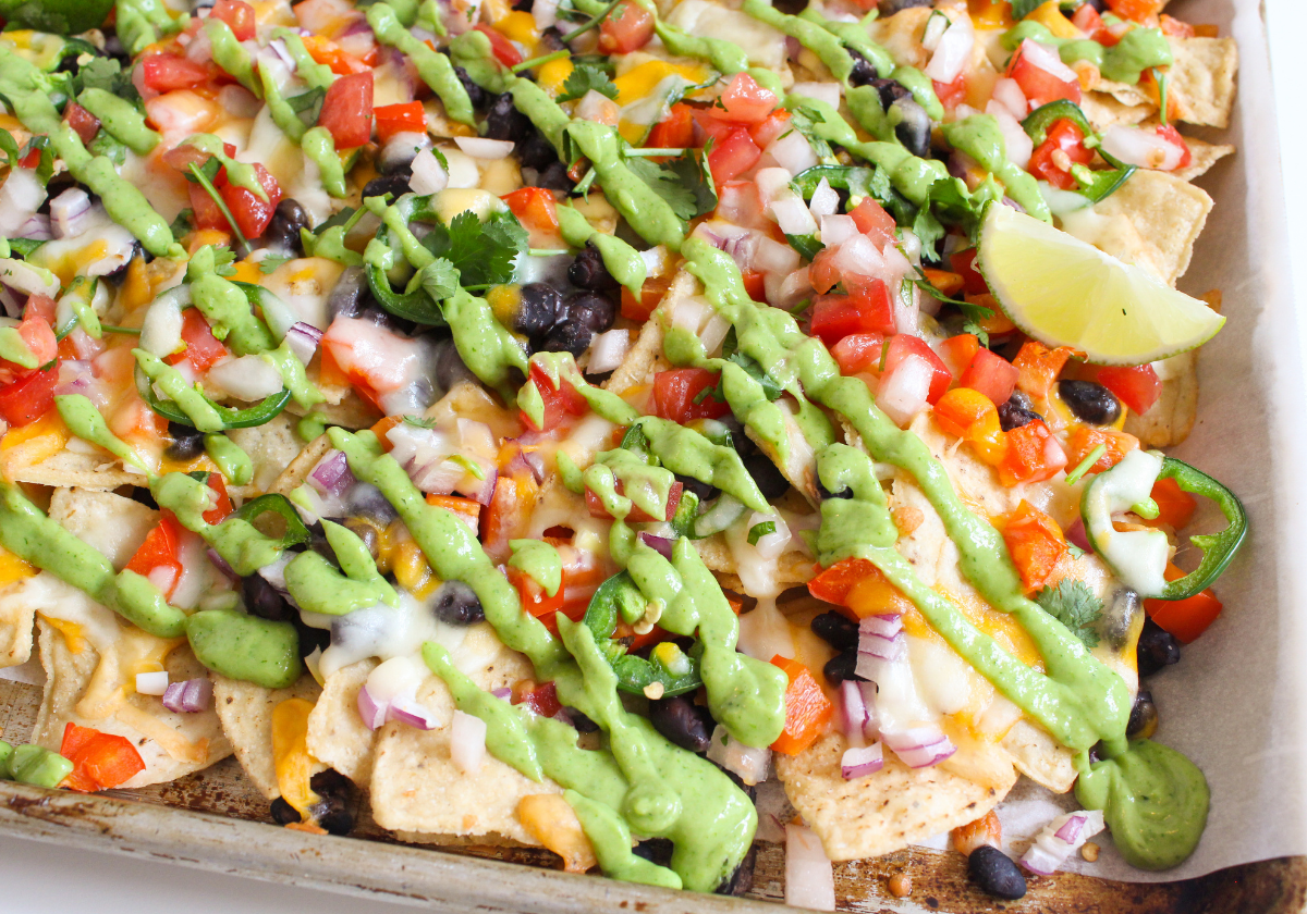 loaded sheet pan vegetarian nachos with avocado crema