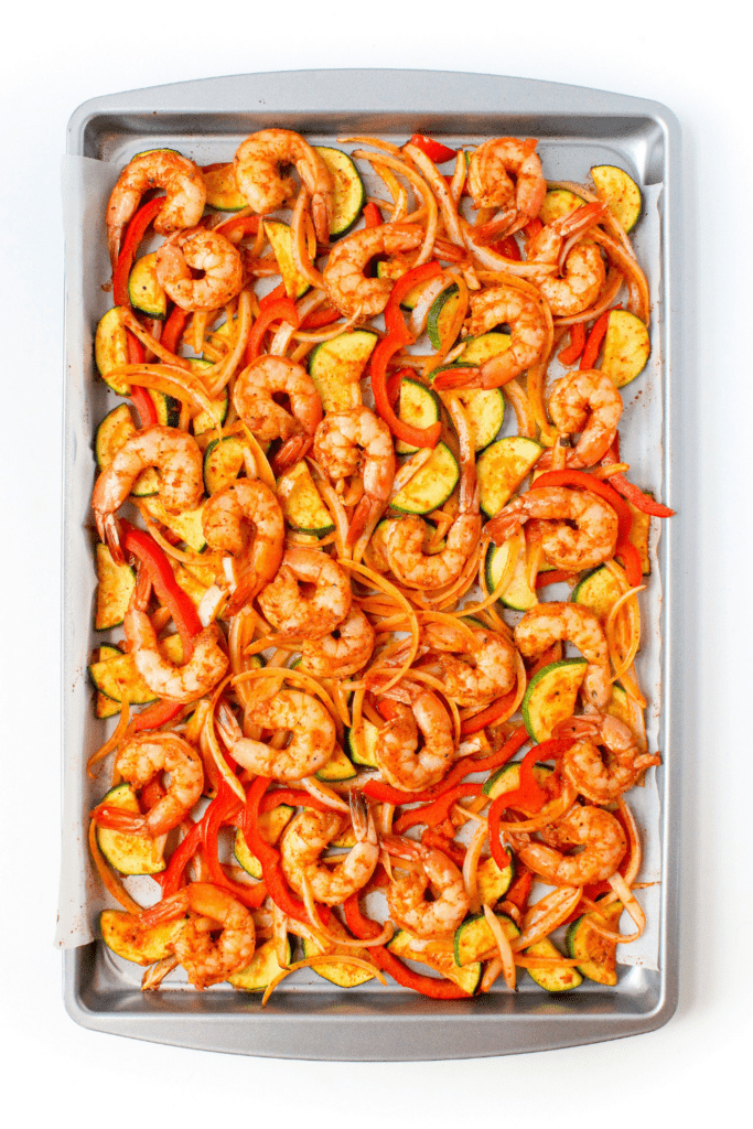 cooked shrimp and vegetables on a sheet pan