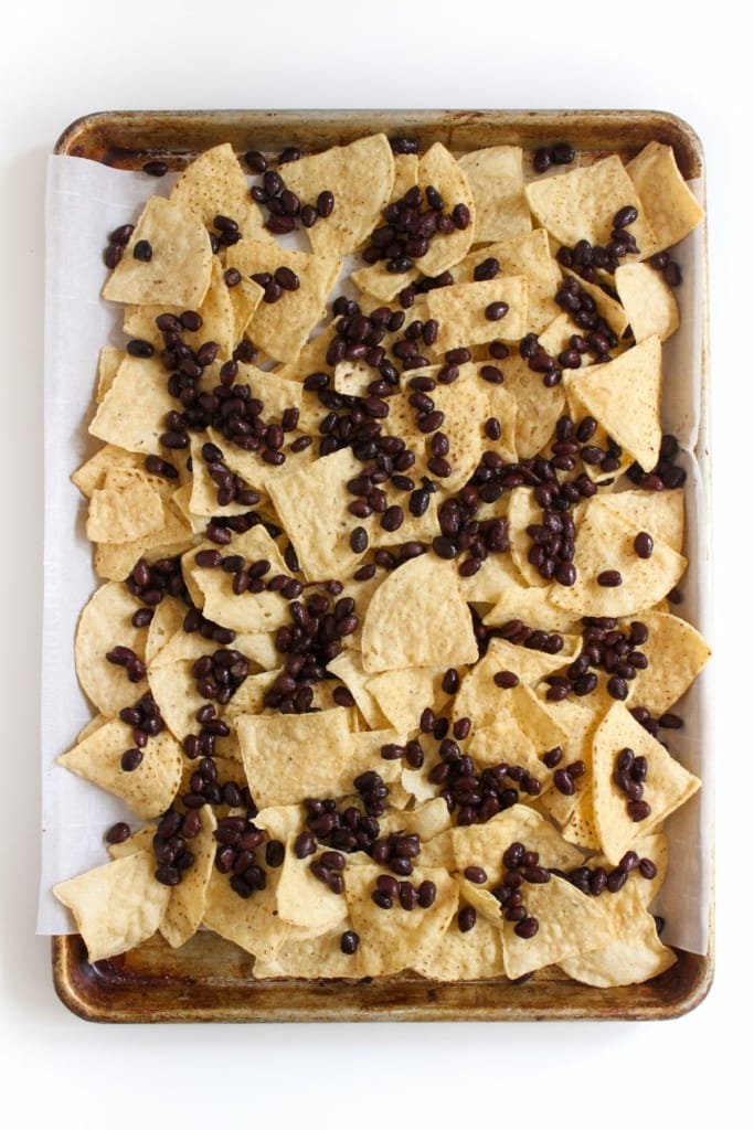 tortilla chips and black beans on a sheet pan