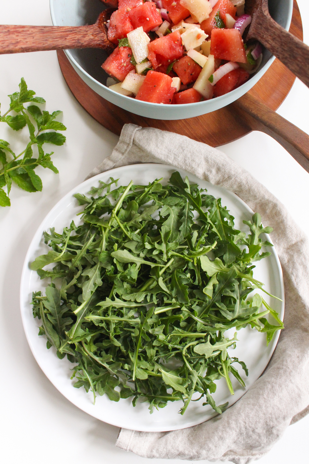 a plate with arugula and salad ingredients on the side