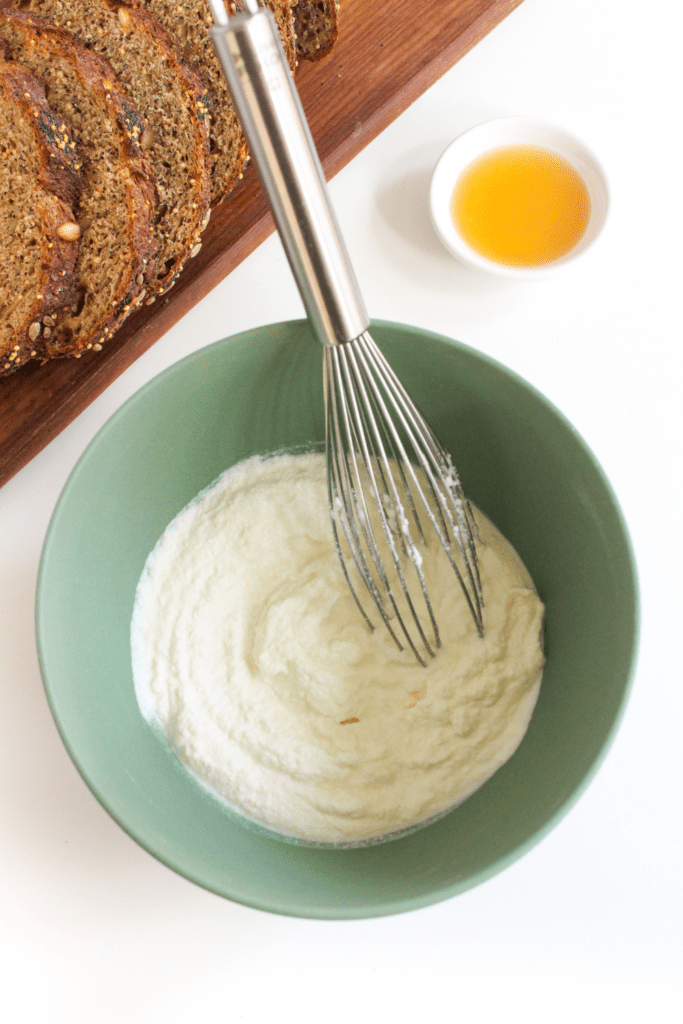 whipped ricotta in a bowl with a whisk