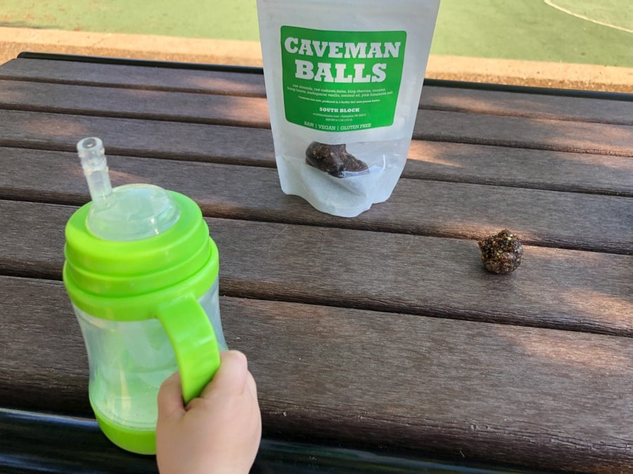 snack balls and toddler water bottle on a picnic table.