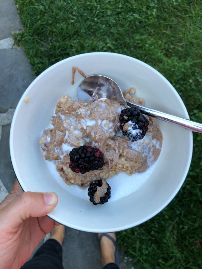 oatmeal with sprouted almond butter and berries in a bowl.