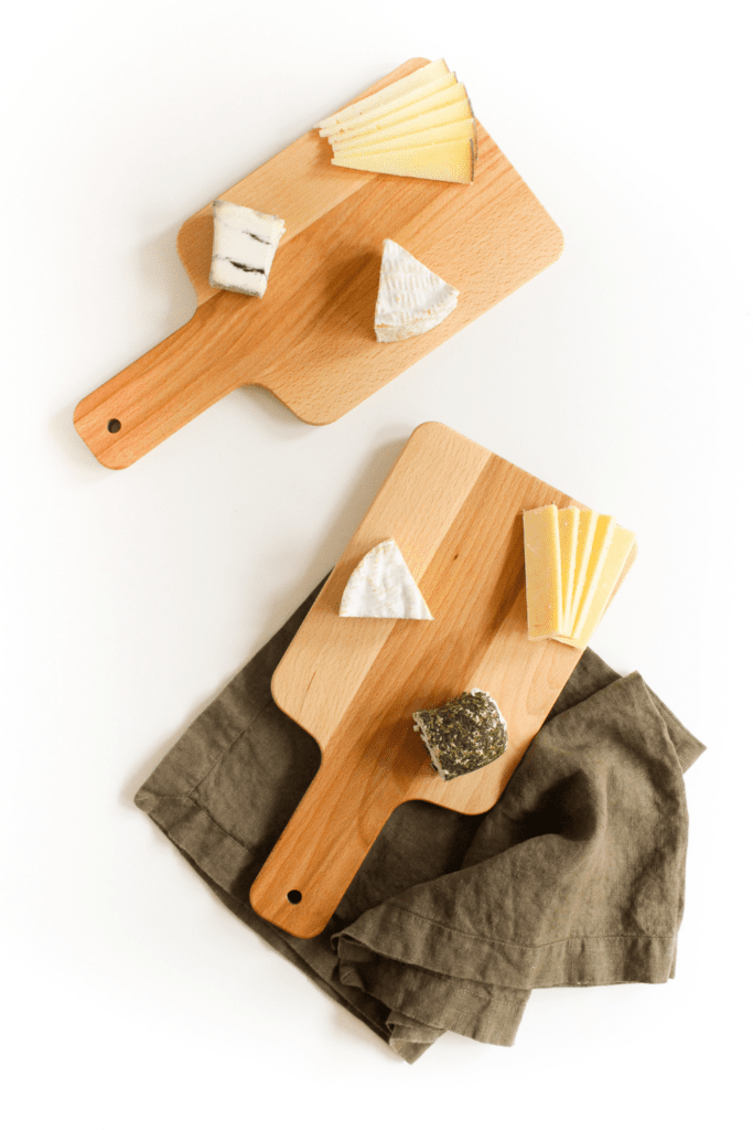 wedges of cheese on a small wooden board
