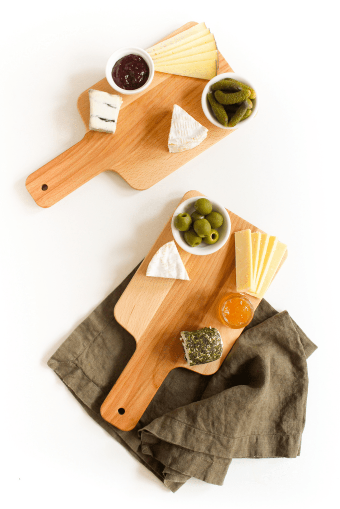 jam, pickles, and olives on a small cheese platter