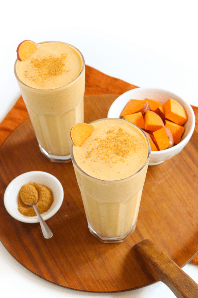 fall smoothie in a tall glass topped with cinnamon