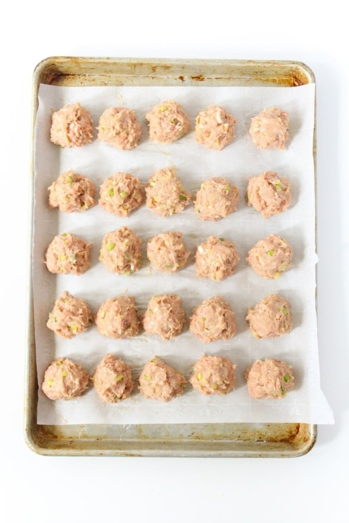 asian meatballs on a sheet pan lined with parchment paper
