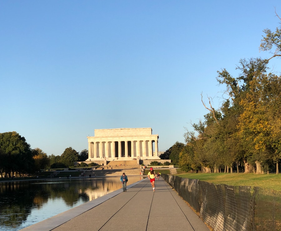 person dressed like forrest gump running in front of lincoln memorial.