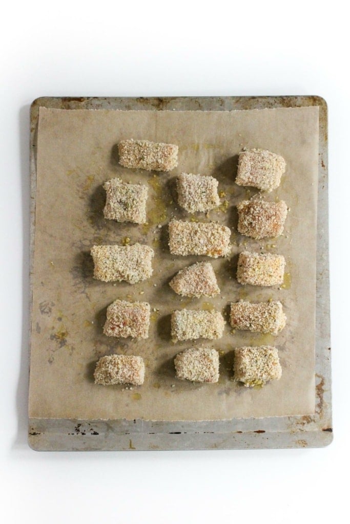 uncooked breaded salmon cubes on a sheet pan