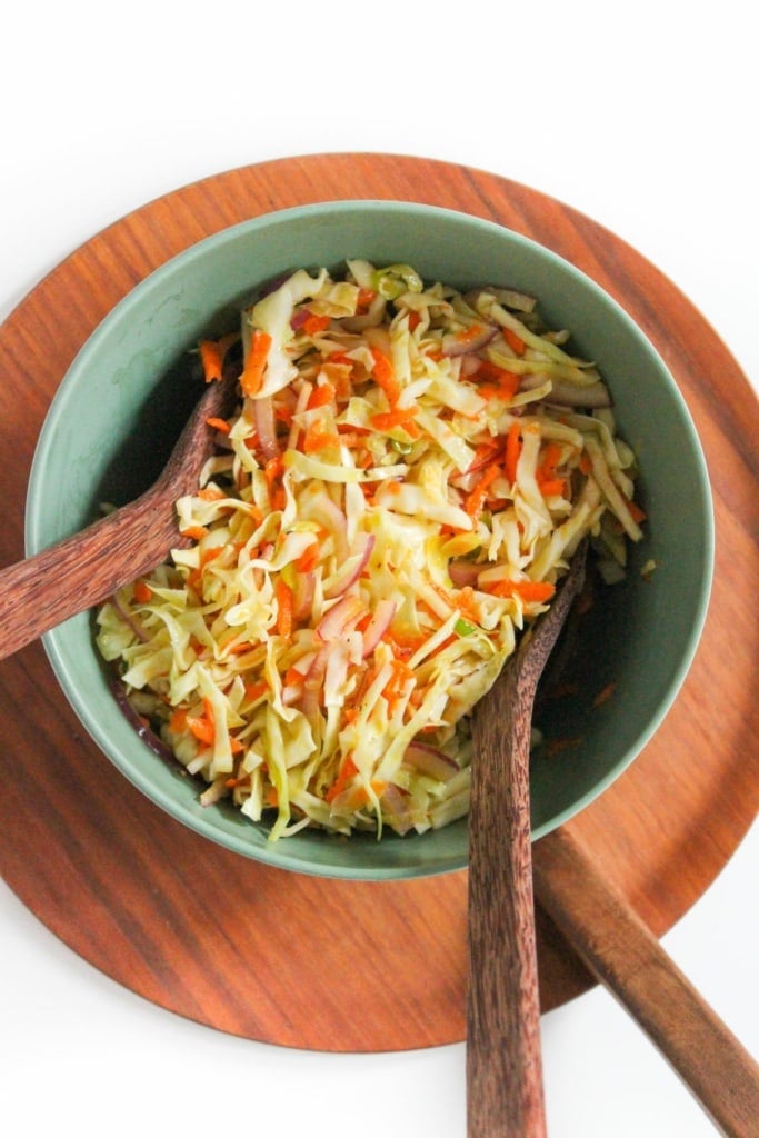 bowl with coleslaw and wooden spoons