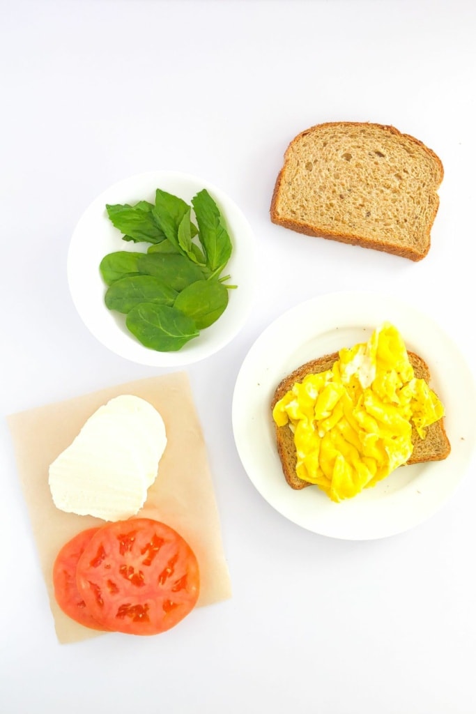 caprese sandwich ingredients with scrambled egg on bread