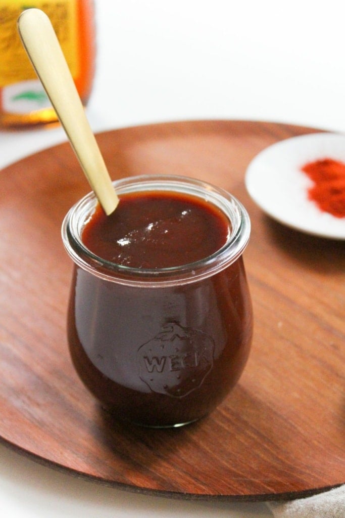 homemade bbq sauce in a jar with a gold spoon