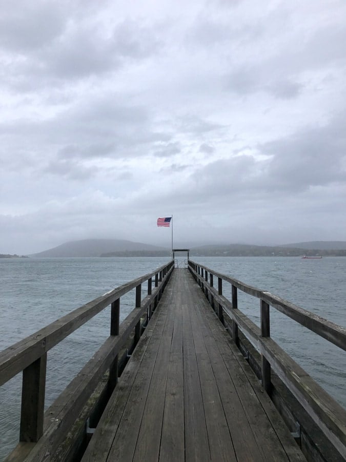 a dock with an american flag in stormy weather