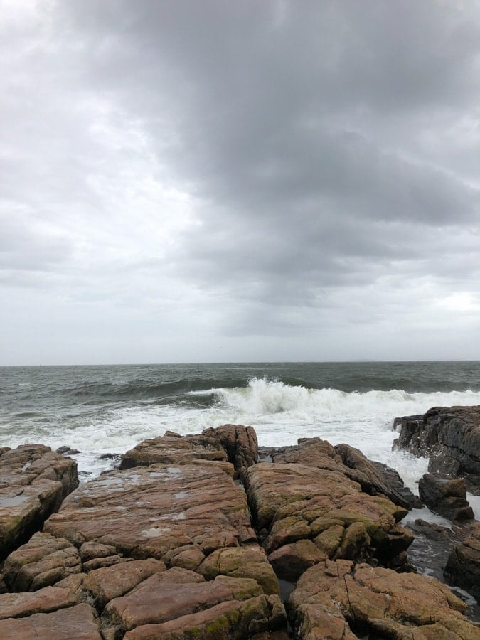 waves crashing on rocks on the coast in maine