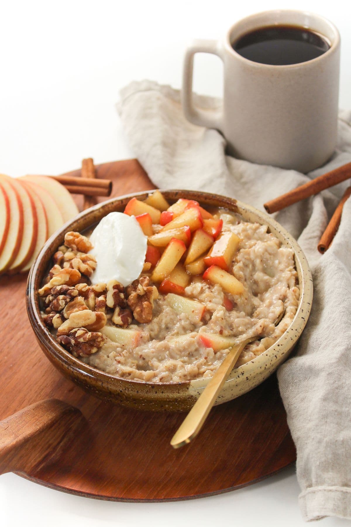 apple cinnamon oatmeal in a bowl with a mug of coffee