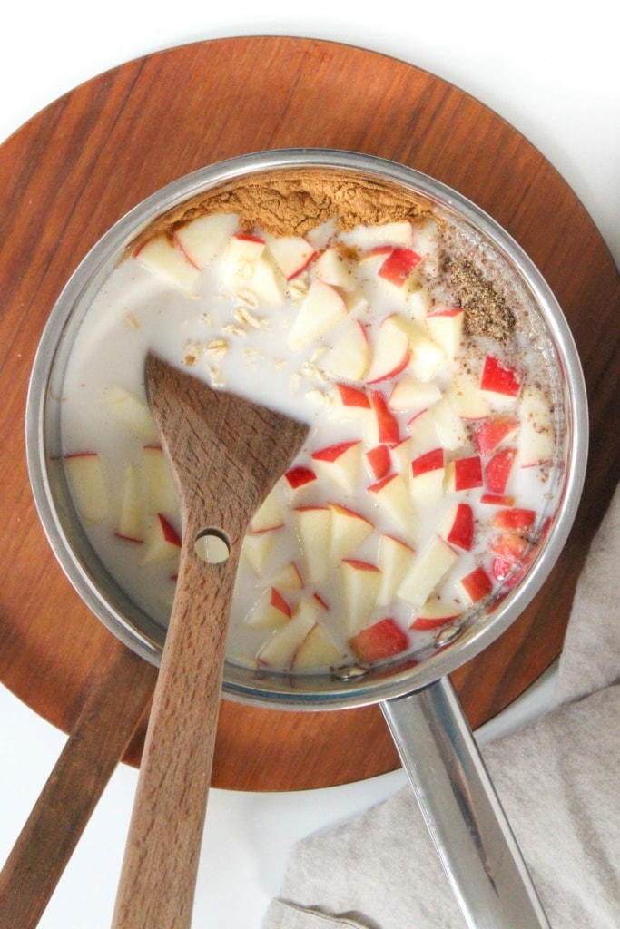 diced apple and oats with milk in a saucepan