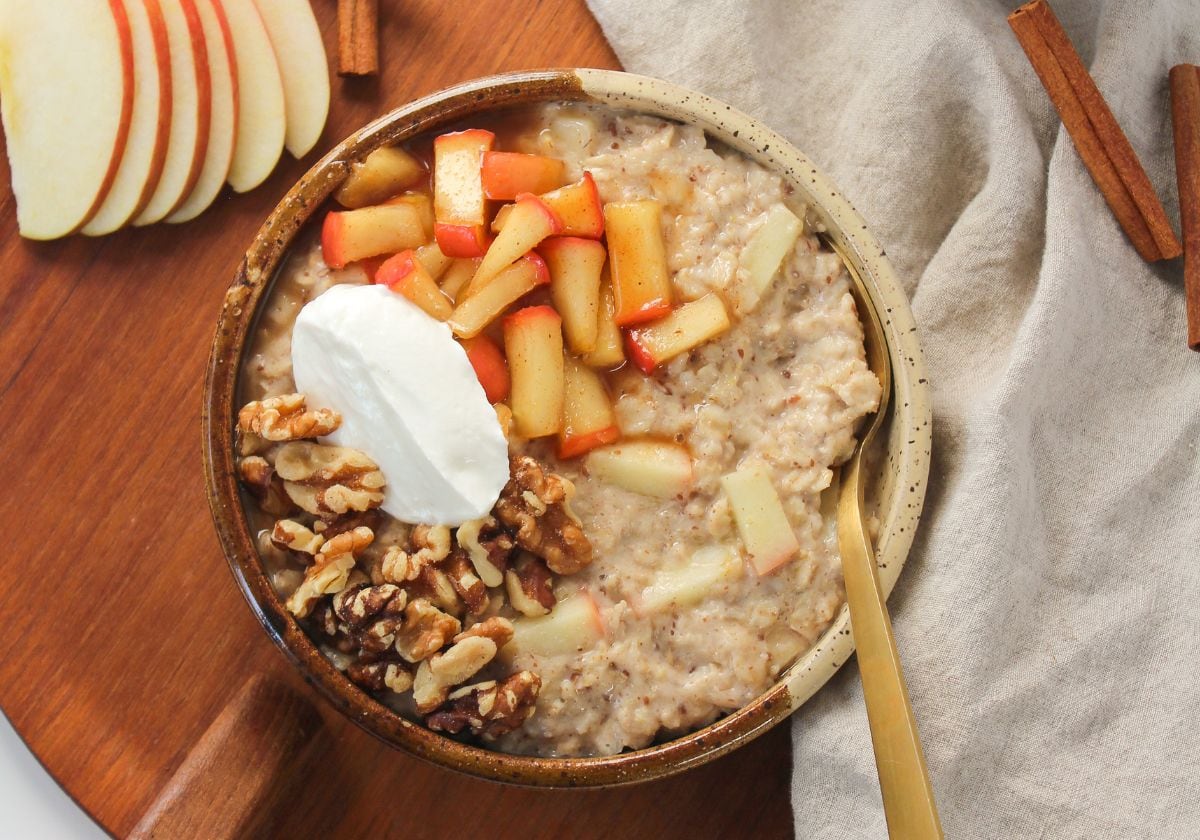 cinnamon oatmeal in a bowl with sauteed apples and walnuts