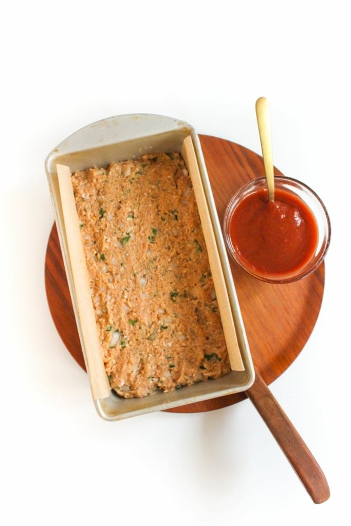 ground chicken mixture in a loaf pan with parchment paper