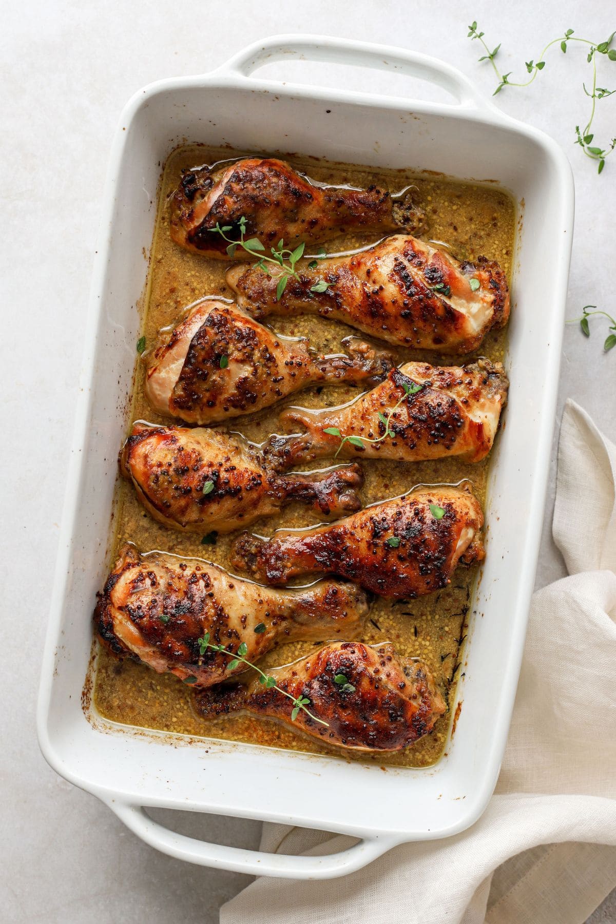 chicken legs in a white baking dish