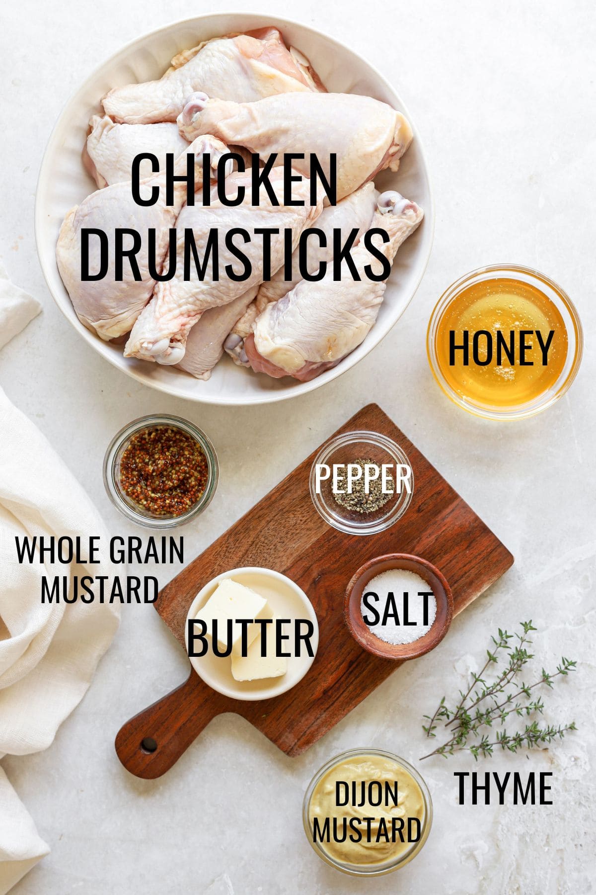raw chicken drumsticks in a bowl next to honey mustard sauce ingredients