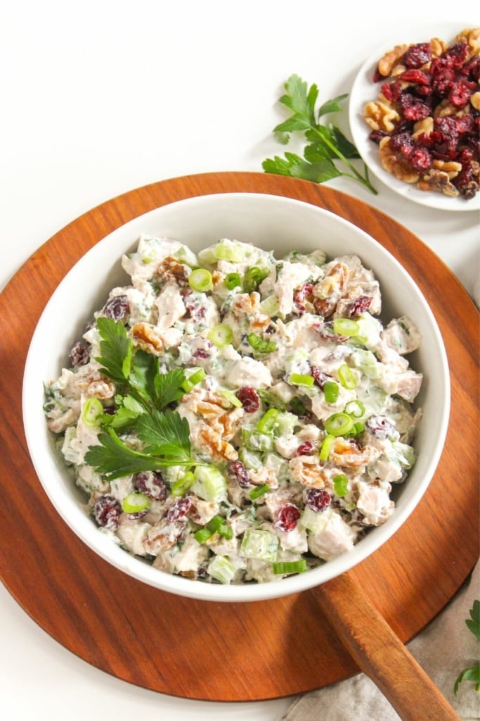 cranberry walnut chicken salad in a bowl with herbs