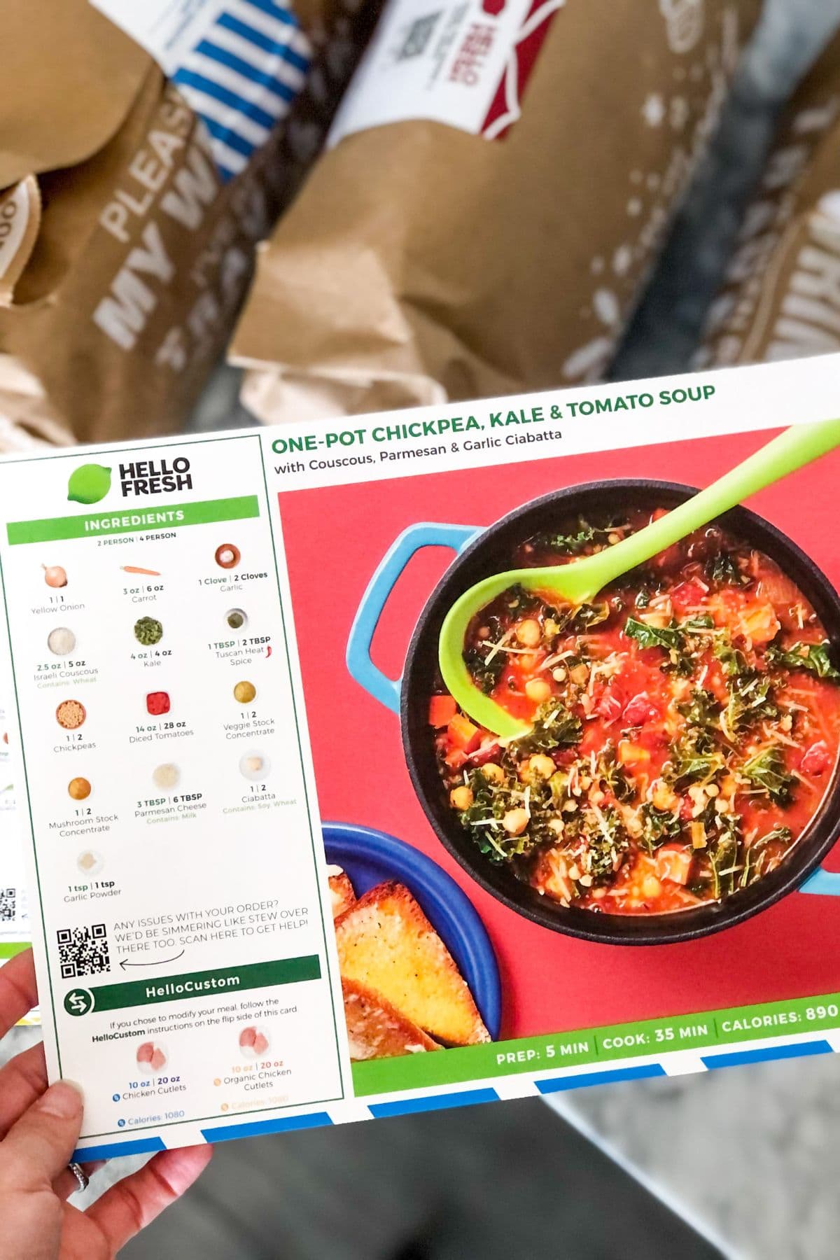 HelloFresh recipe card for chickpea tomato soup in front of paper bags