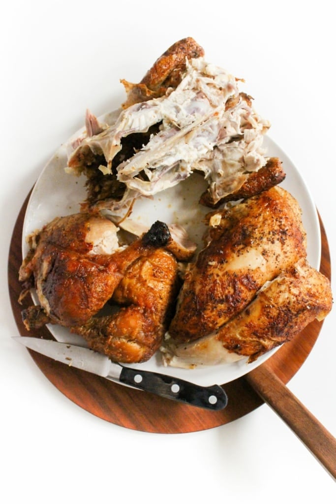 carved chicken with drumsticks removed on a plate