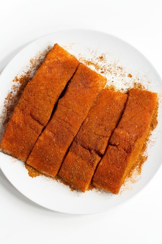 salmon filets coated in seasoning on a plate