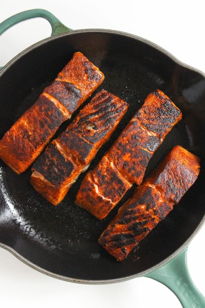 blackened salmon filets in a skillet