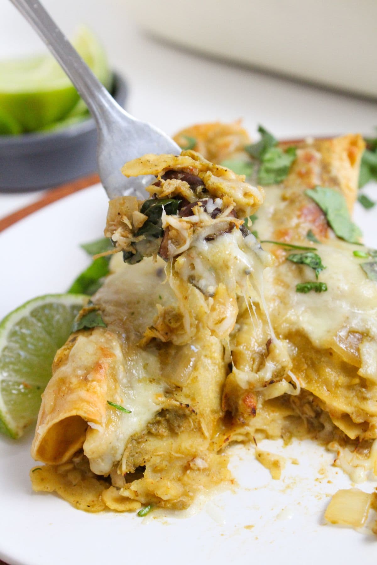 close up of shredded chicken enchiladas with green sauce